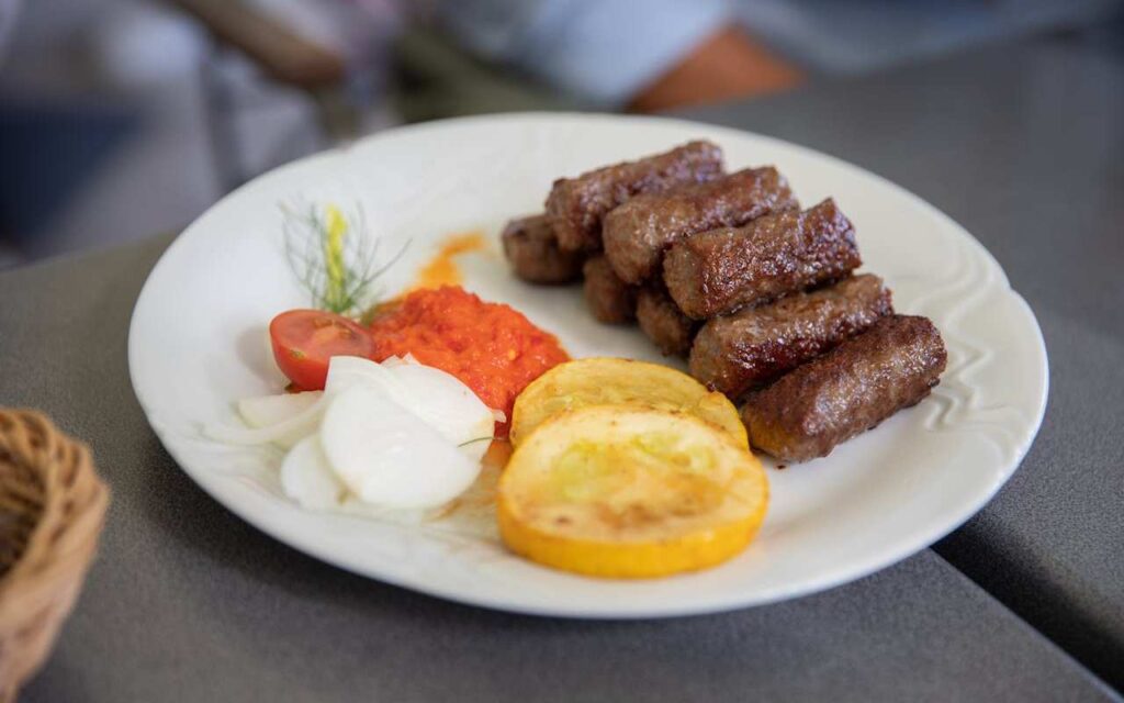 Tanjir sa ćevapima, limunom, lukom, ajvarom